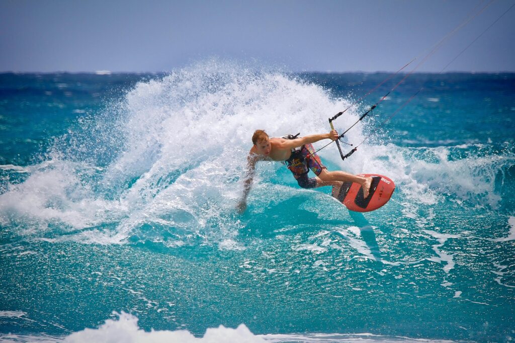 Thrilling kitesurfing moment captured as a surfer rides the waves in vibrant ocean waters.