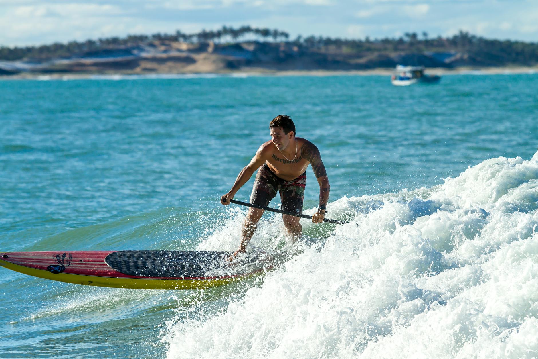 A man paddleboarding on ocean waves, showcasing thrilling water sports action.